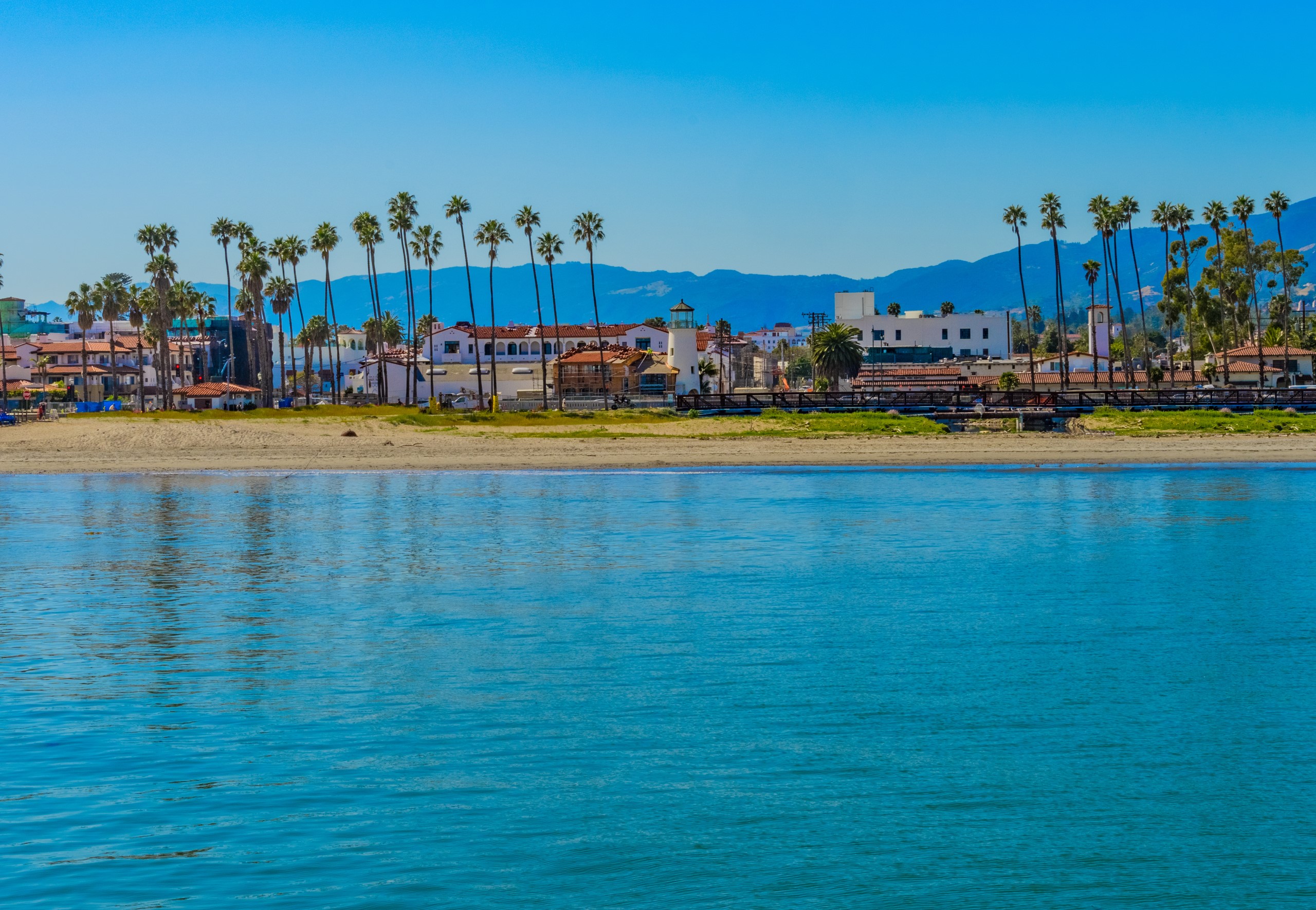 safe harbor; Southern California recreation; Santa Barbara Harbor, mountain range, leisure boats, water reflections, clear sky, still water